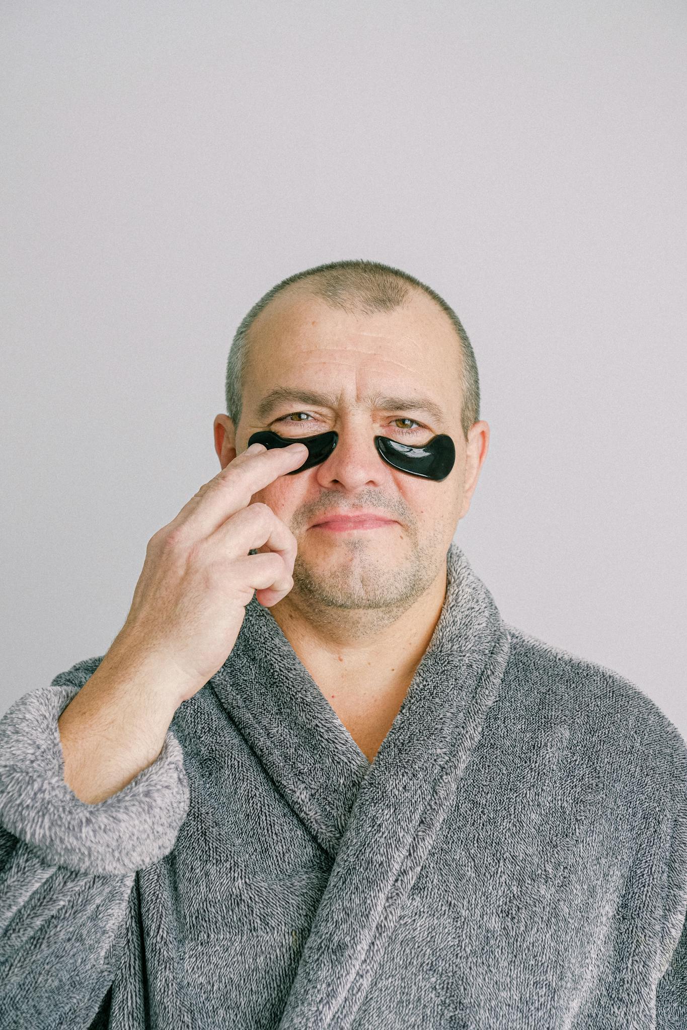 Man in Gray Bathrobe Wearing Black Eye Mask